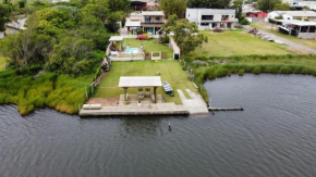 Casa na beira da lagoa com piscina e rampa para embarcações